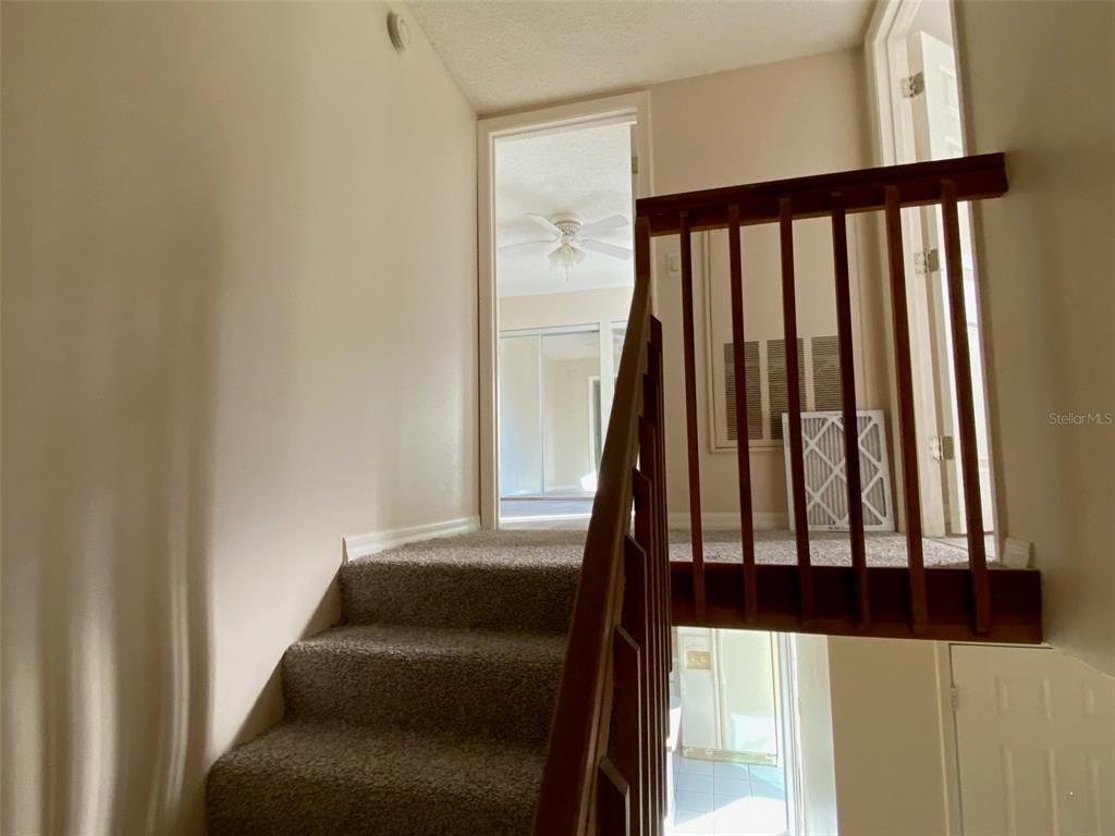 2911 Pecan Avenue Leesburg, FL 34748 - Photo 10 of 26 a view of staircase with wooden floor and white walls
