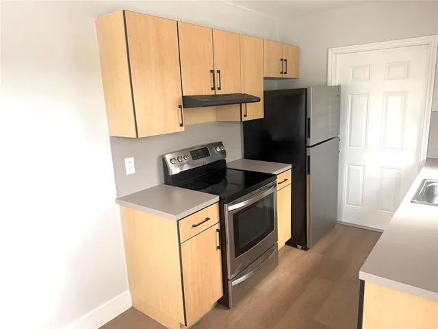 a kitchen with a refrigerator sink and cabinets