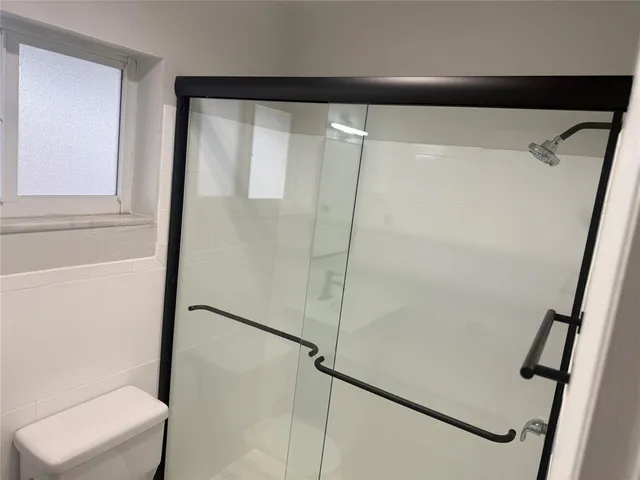 a bathroom with a glass shower door