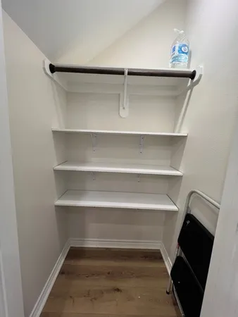a view of walk in closet with empty racks