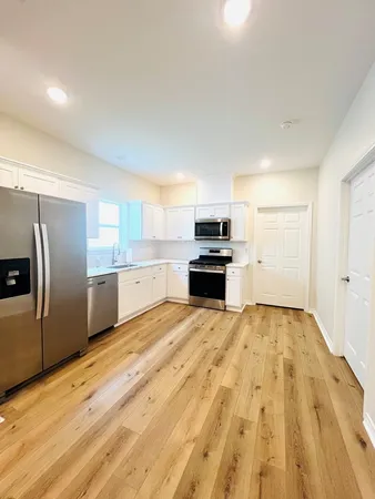 a large kitchen with kitchen island a sink stainless steel appliances and cabinets