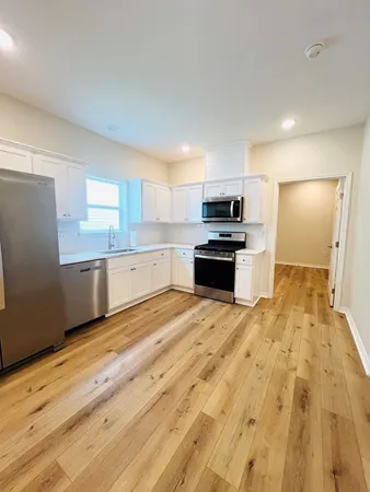 a kitchen with granite countertop a refrigerator and a sink