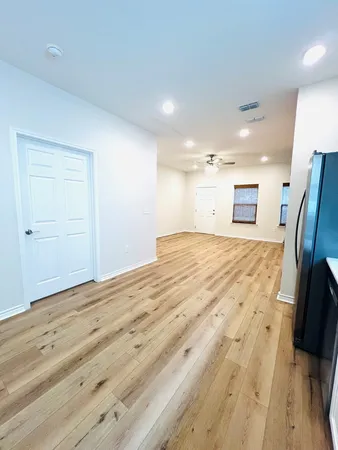 a view of empty room with wooden floor