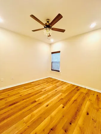 a view of a room with wooden floor and a ceiling fan