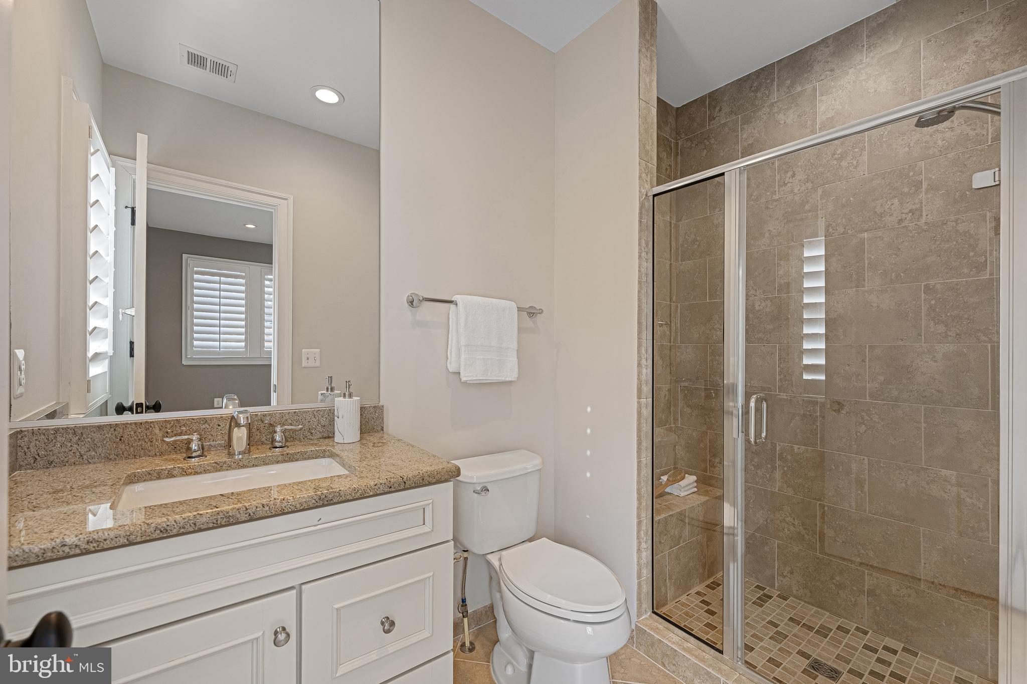 6520 Topeka Road McLean, VA 22101 - Photo 50 of 67 a bathroom with a granite countertop sink a toilet and shower