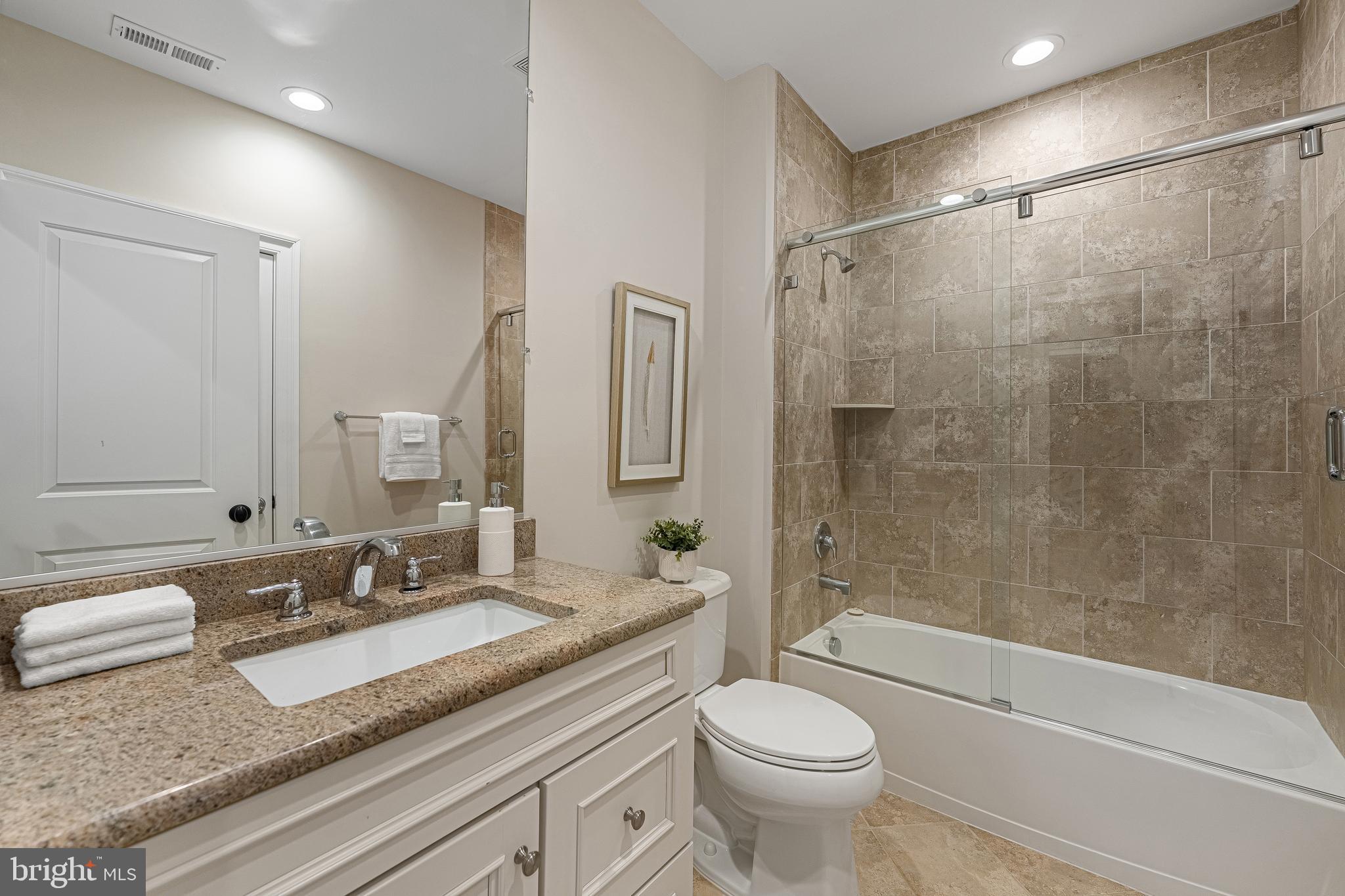 6520 Topeka Road McLean, VA 22101 - Photo 60 of 67 a bathroom with a granite countertop sink a toilet and shower