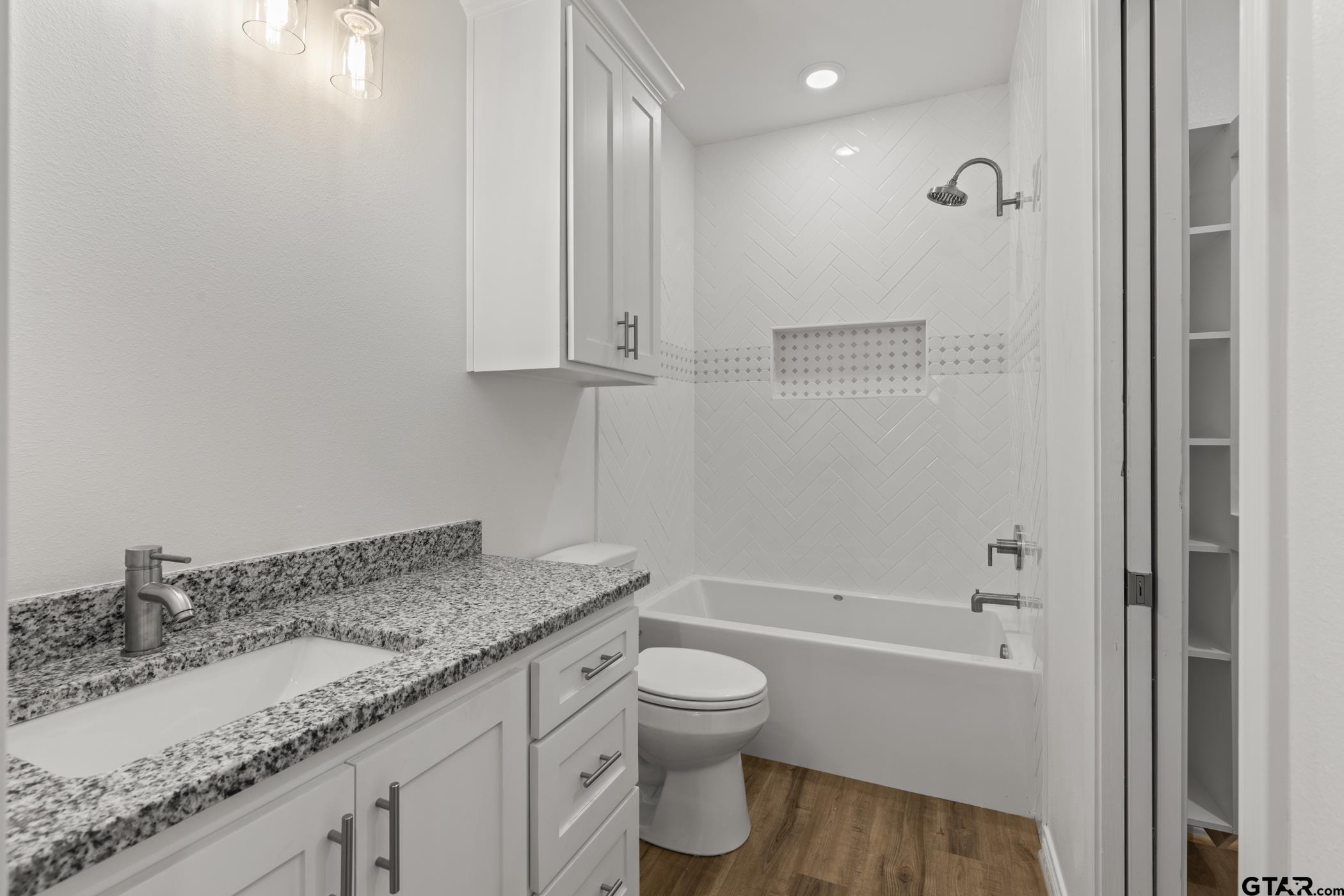 712 West 3rd Tyler, TX 75701 - Photo 21 of 28 a bathroom with a granite countertop sink a toilet and shower