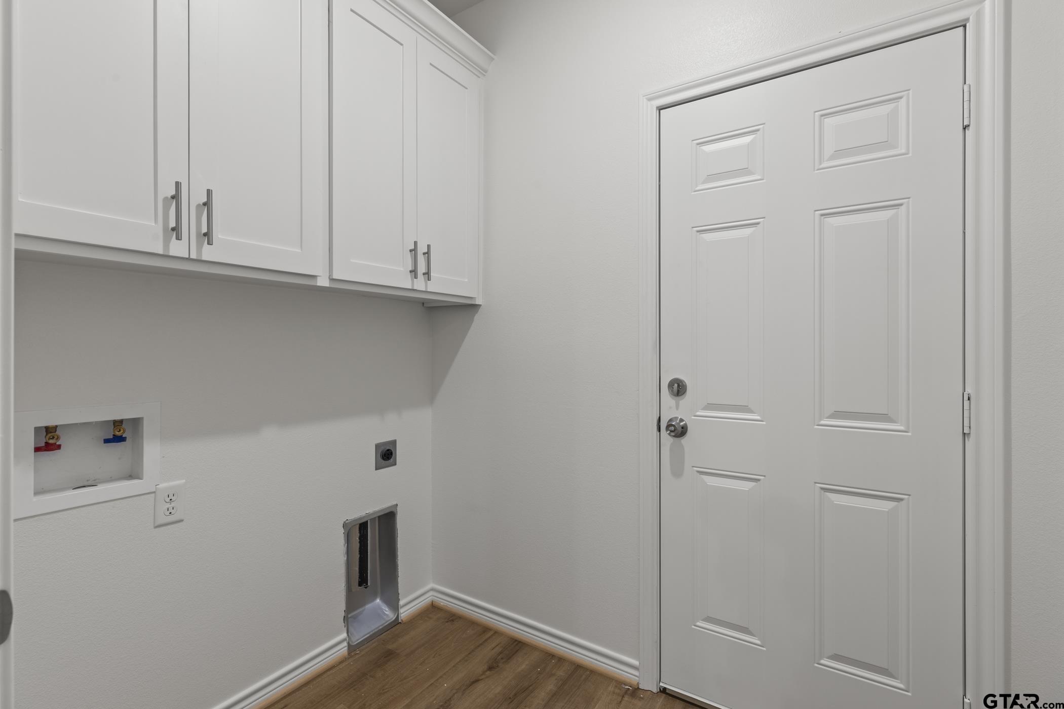 712 West 3rd Tyler, TX 75701 - Photo 24 of 28 a view of cabinets and utility room with wooden floor