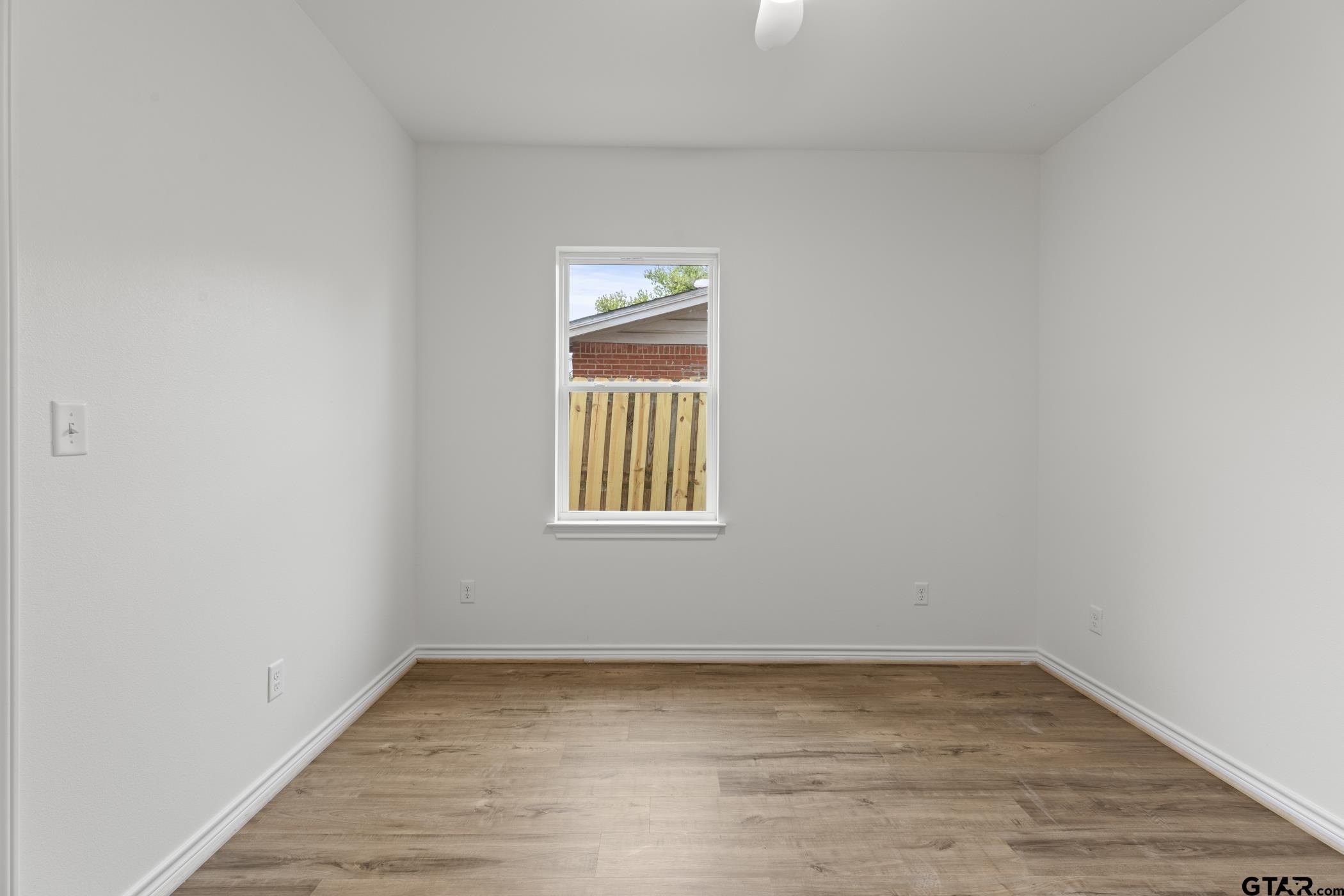 712 West 3rd Tyler, TX 75701 - Photo 25 of 28 a view of an empty room with wooden floor and a window