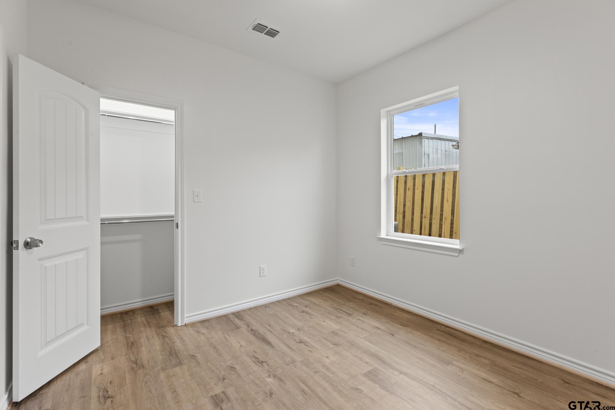 712 West 3rd Tyler, TX 75701 - Photo 26 of 28 a view of an empty room with wooden floor and a window