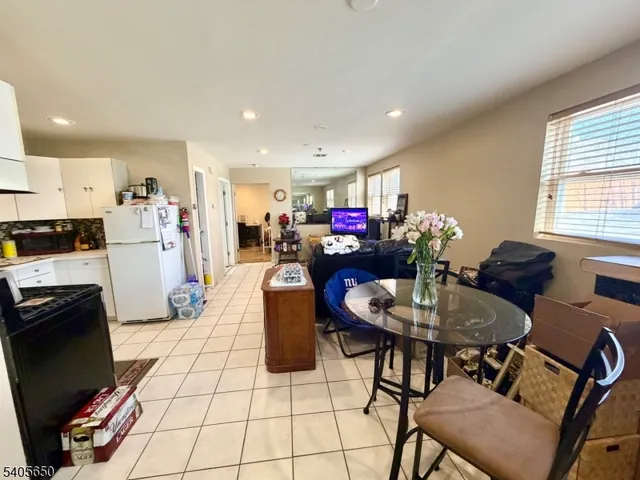 a living room with furniture a flat screen tv and kitchen view