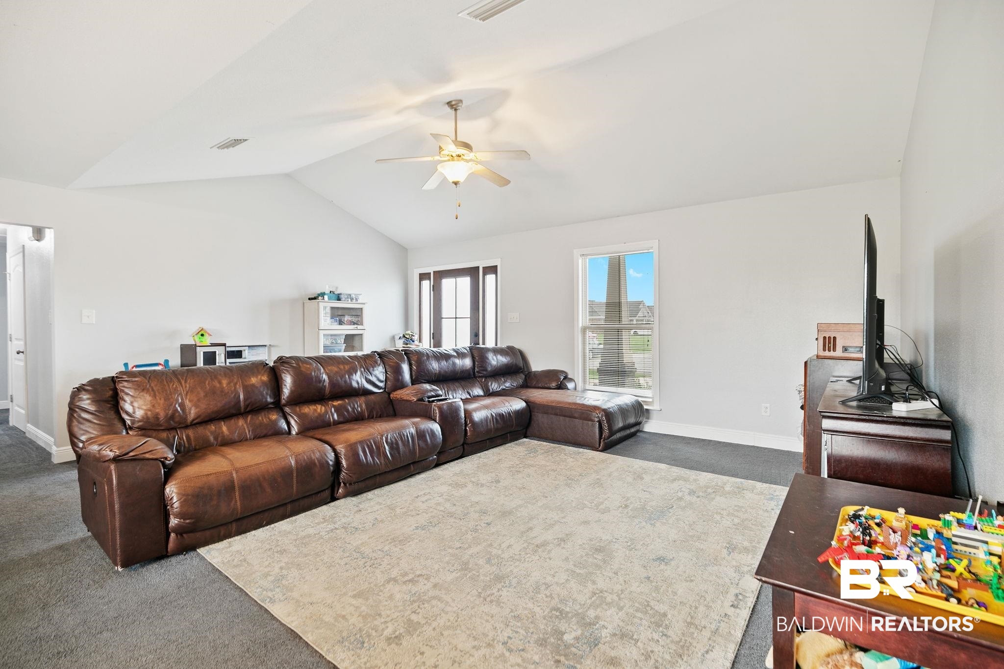 15573 Talus Court Foley, AL 36535 - Photo 12 of 50 Living room featuring dark colored carpet, ceiling fan, and lofted ceiling