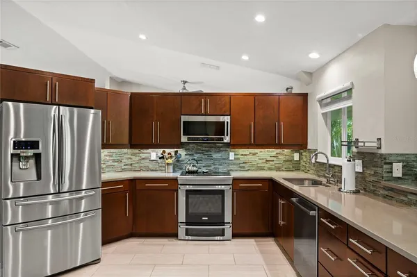 a kitchen with kitchen island granite countertop stainless steel appliances and cabinets