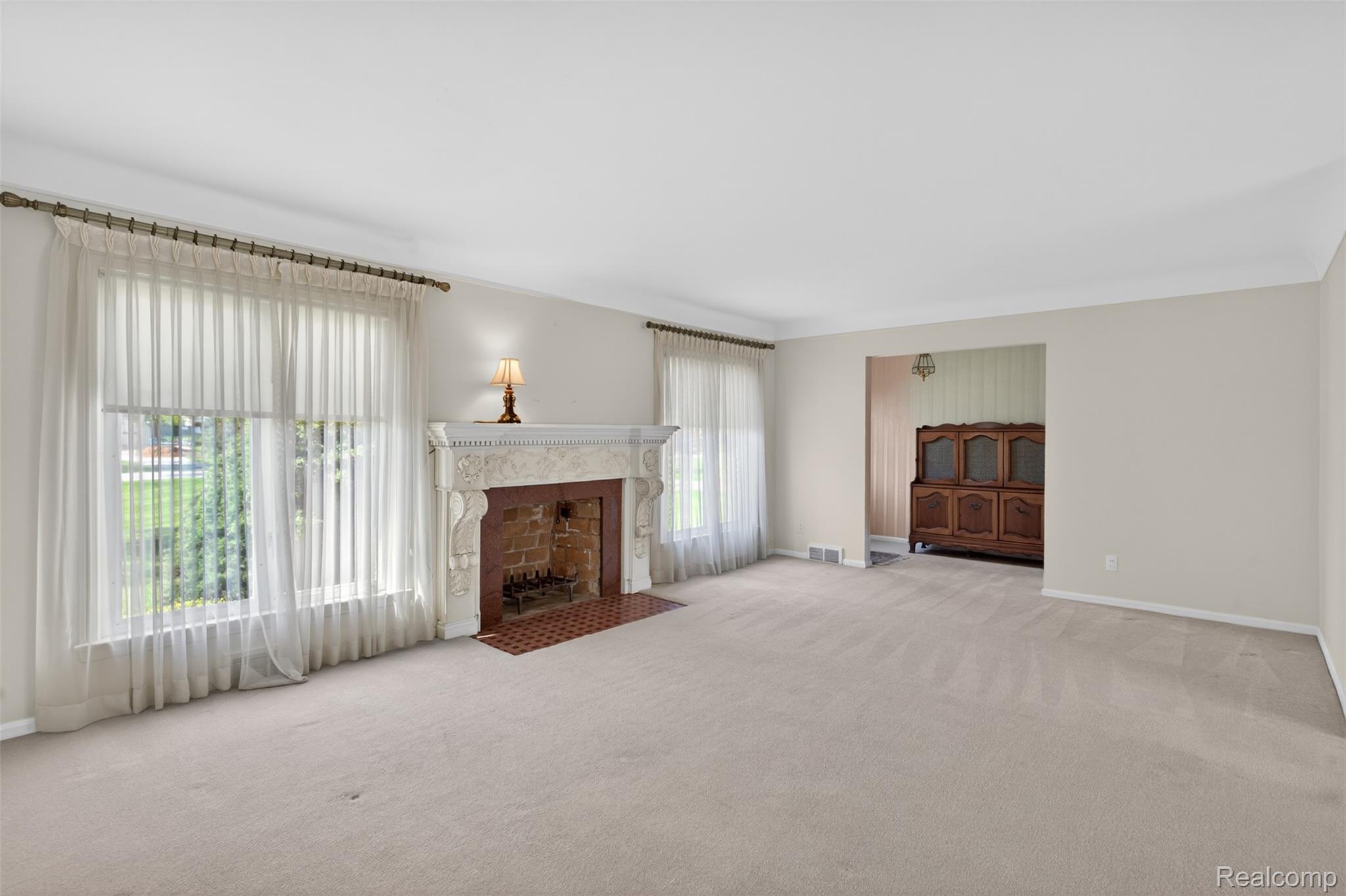 15623 Millar Road Clinton Township, MI 48036 - Photo 25 of 56 Unfurnished living room featuring light carpet and a fireplace with flush hearth