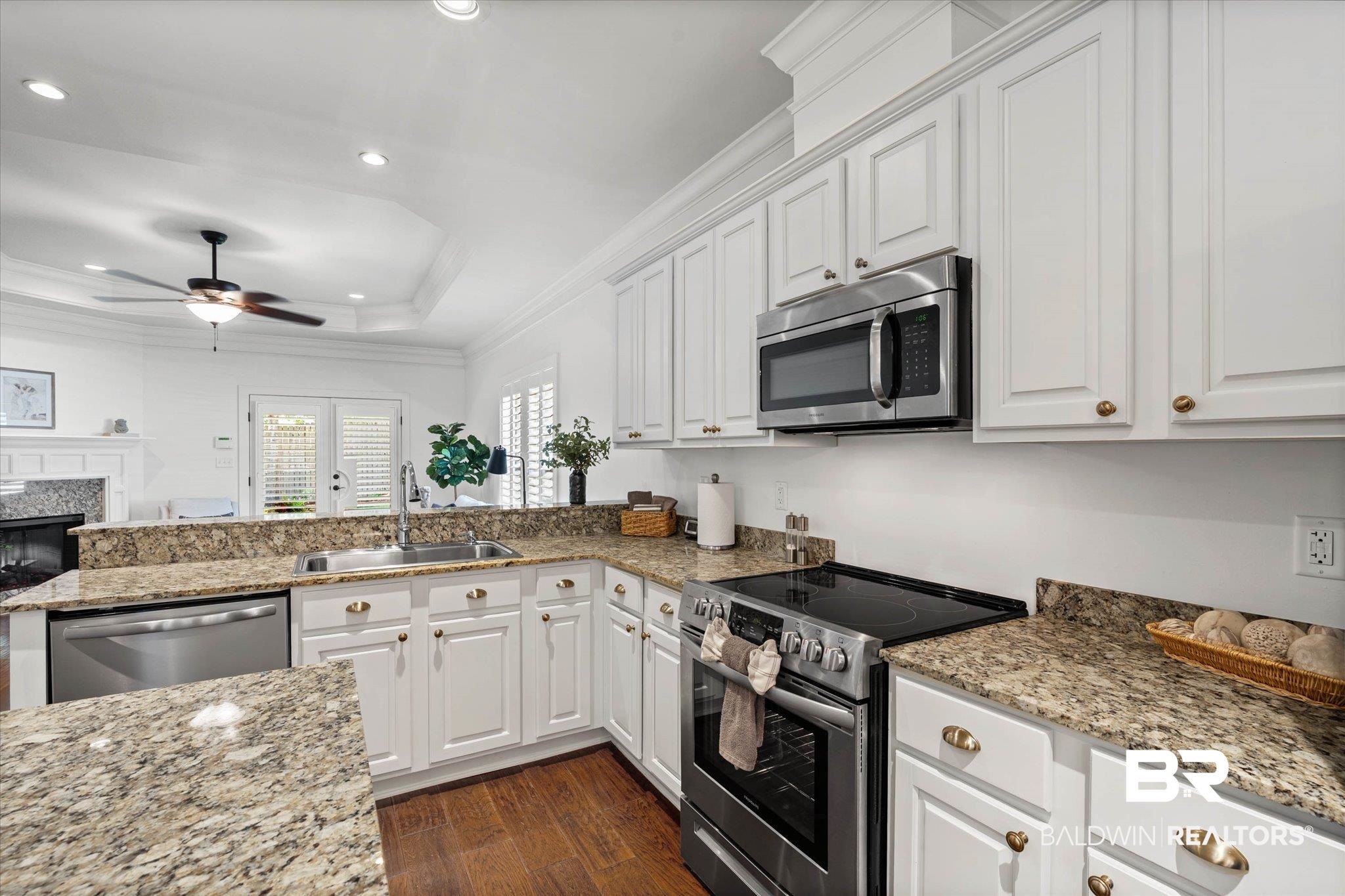 1052 Linlen Avenue Mobile, AL 36609 - Photo 6 of 22 Kitchen featuring stainless steel appliances, crown molding, light stone counters, a high end fireplace, and ceiling fan