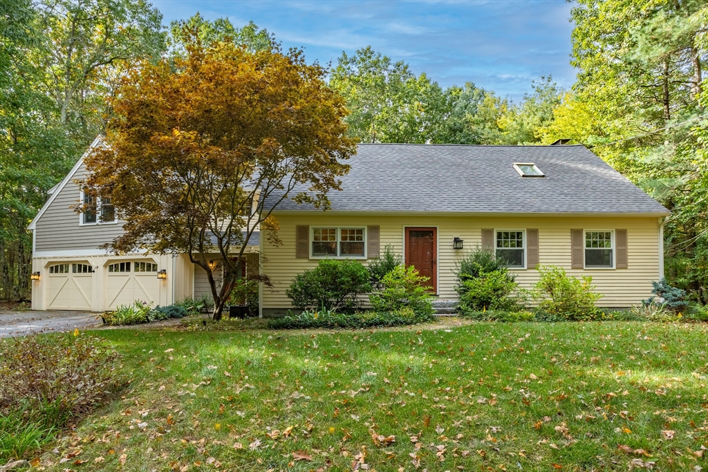 a front view of a house with a yard and trees