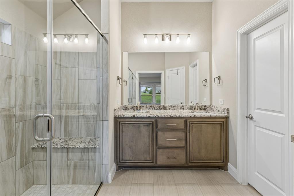 2137 Charming Frg Road Forney, TX 75126 - Photo 19 of 35 a bathroom with a granite countertop sink a mirror and a shower