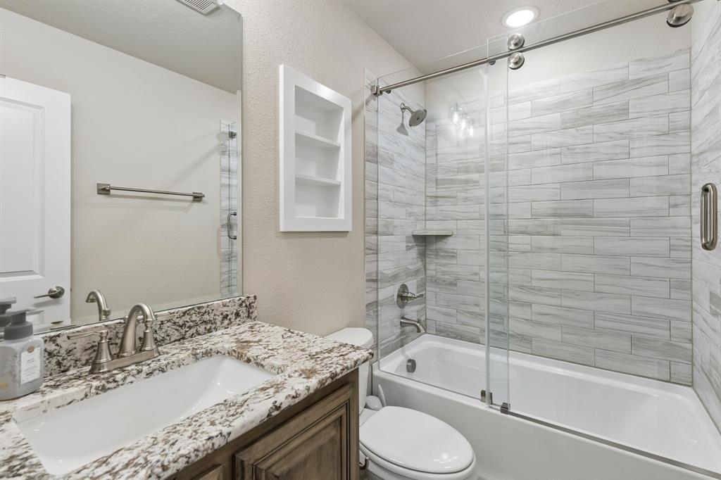 2137 Charming Frg Road Forney, TX 75126 - Photo 23 of 35 a bathroom with a granite countertop sink toilet and shower