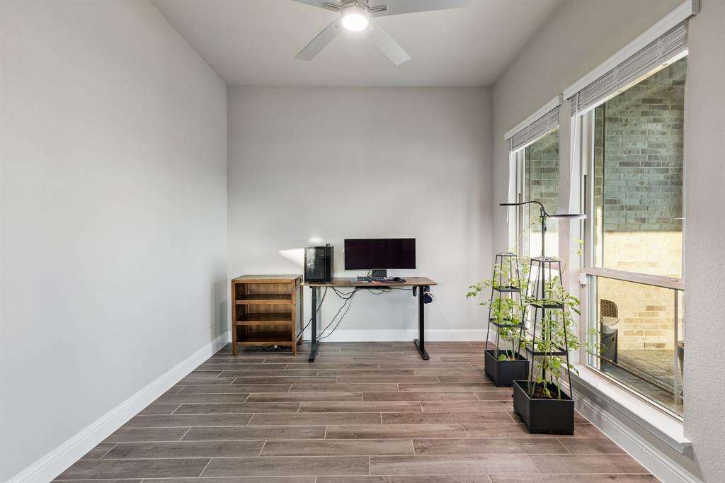 2137 Charming Frg Road Forney, TX 75126 - Photo 27 of 35 a living room with furniture a flat screen tv and a floor to ceiling window