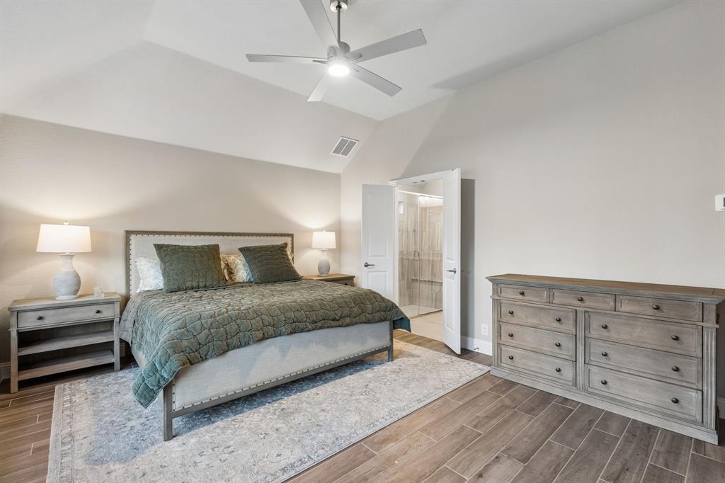 2137 Charming Frg Road Forney, TX 75126 - Photo 5 of 35 a bedroom with a large bed and a chandelier