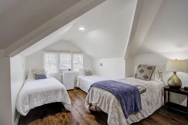 a bedroom with two beds and a large window
