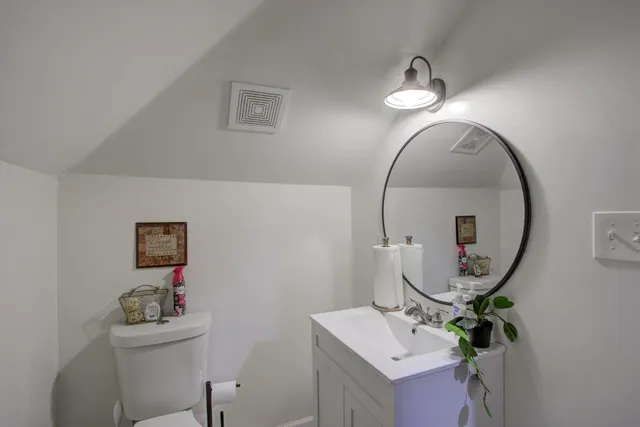 a bathroom with a sink mirror and a toilet