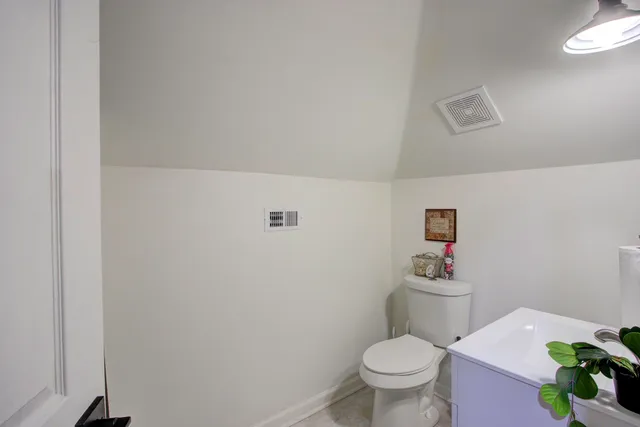 a white toilet sitting next to a bathroom sink and vanity