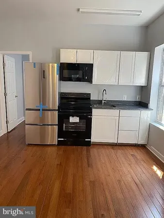 a kitchen with wooden floors and appliances