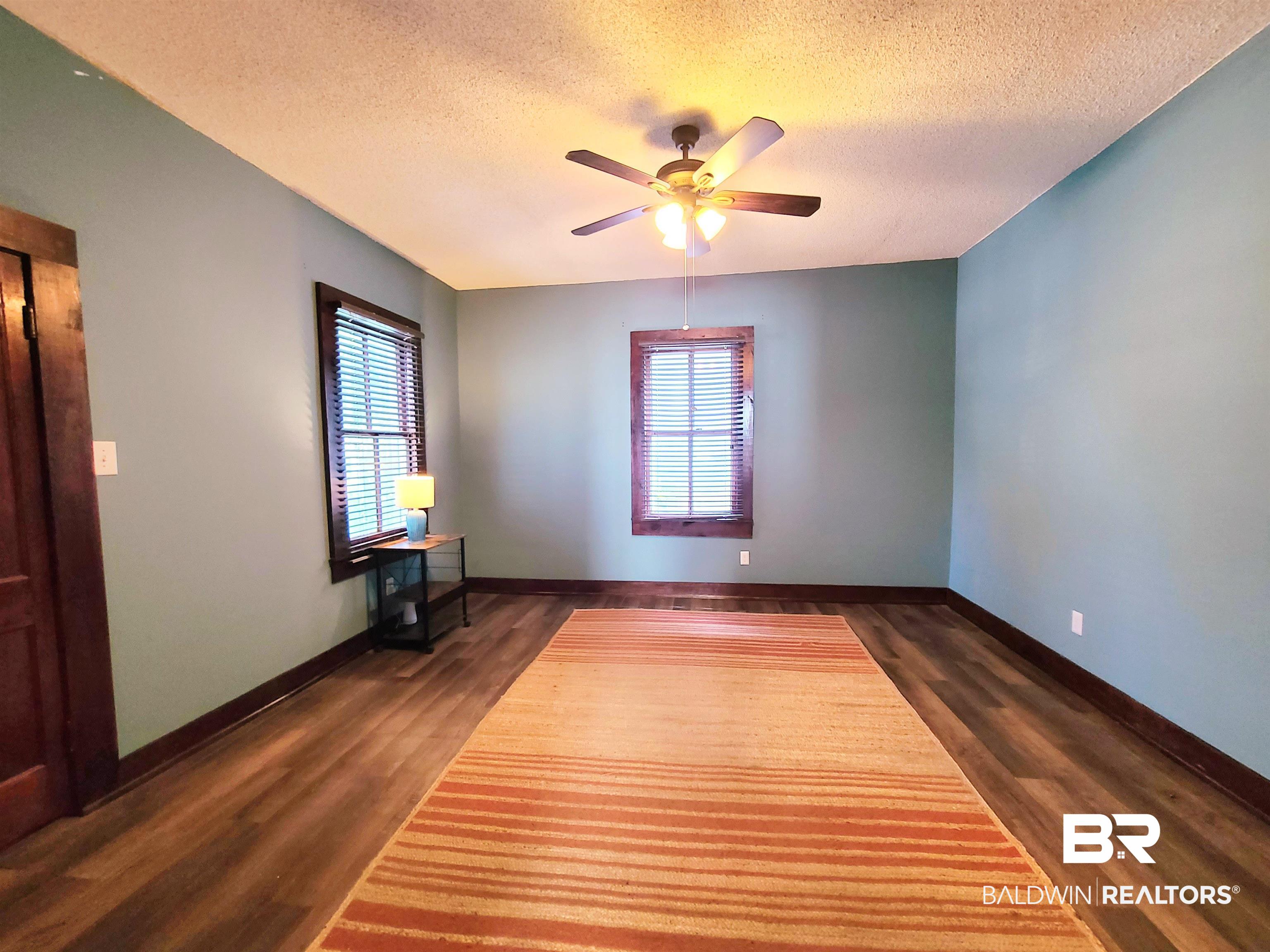 112 Espejo Street Mobile, AL 36604 - Photo 8 of 20 Empty room with dark wood finished floors, a textured ceiling, and plenty of natural light