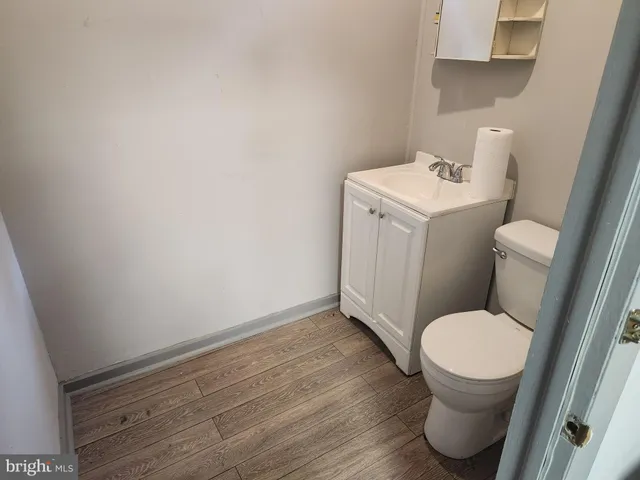 a white toilet sitting next to a sink and vanity