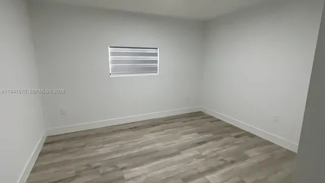 a view of a small space with wooden floor and a window