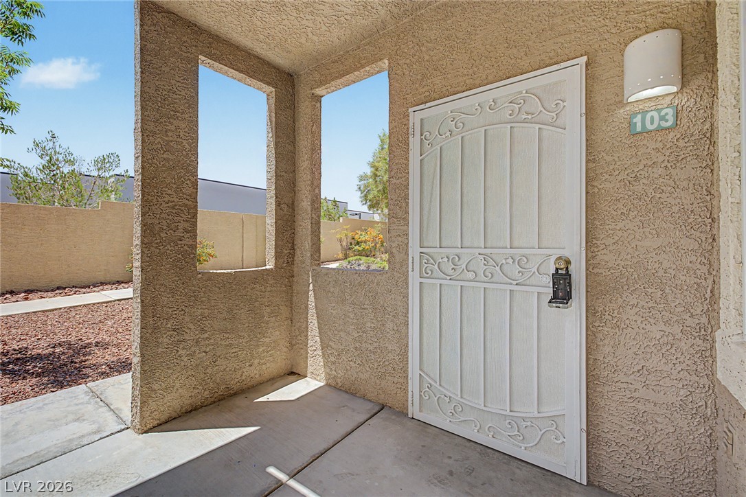 2153 Quarry Ridge Street, Unit 103 Las Vegas, NV 89117 - Photo 11 of 42 Secure entry to a desert oasis with a decorative wrought iron gate and a clear address marker.