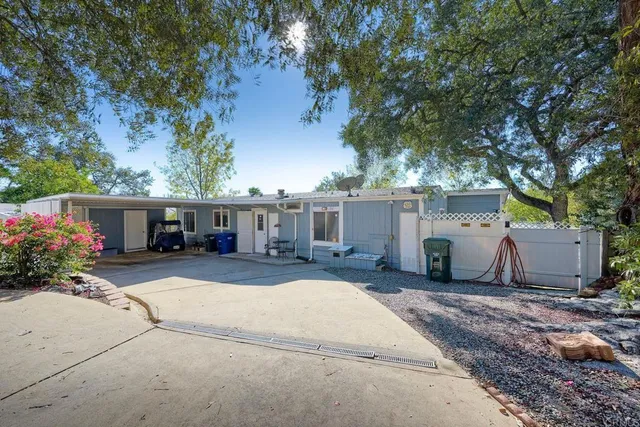 a view of a house with a patio and a yard