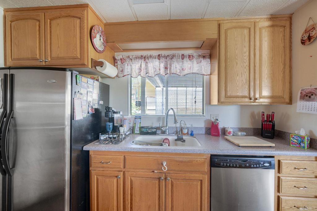 18218 Paradise Mountain Road Valley Center, CA 92082 - Photo 17 of 34 a kitchen with stainless steel appliances granite countertop a sink a refrigerator and cabinets