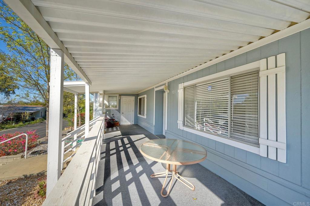 18218 Paradise Mountain Road Valley Center, CA 92082 - Photo 8 of 34 a view of a patio with lawn chairs floor to ceiling window with wooden floor