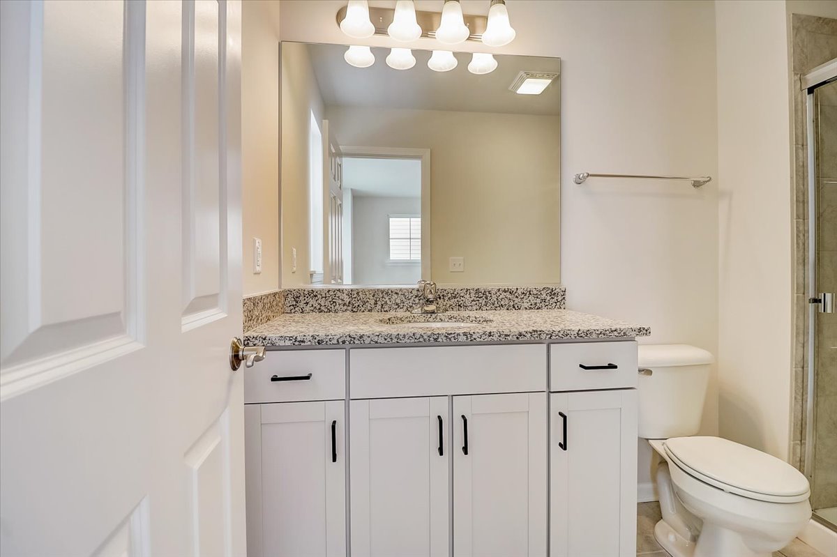715 Station Boulevard Elburn, IL 60119 - Photo 17 of 33 a bathroom with a granite countertop sink a toilet and a mirror