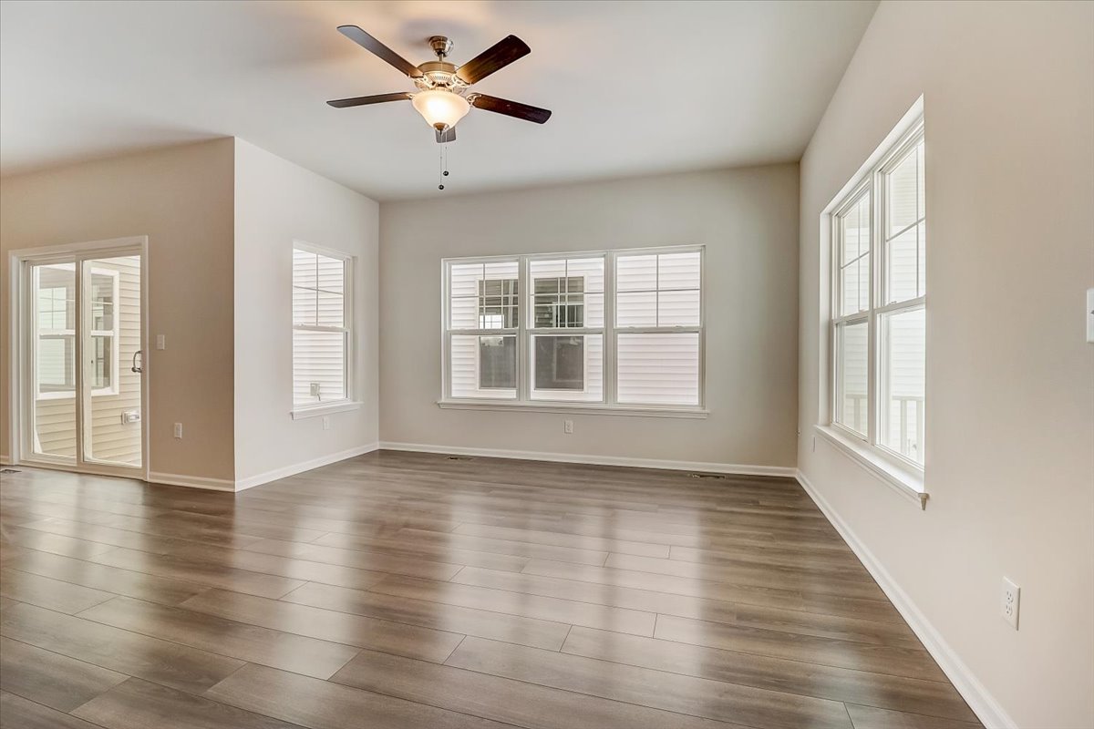 715 Station Boulevard Elburn, IL 60119 - Photo 2 of 33 wooden floor in an empty room with a window and a kitchen