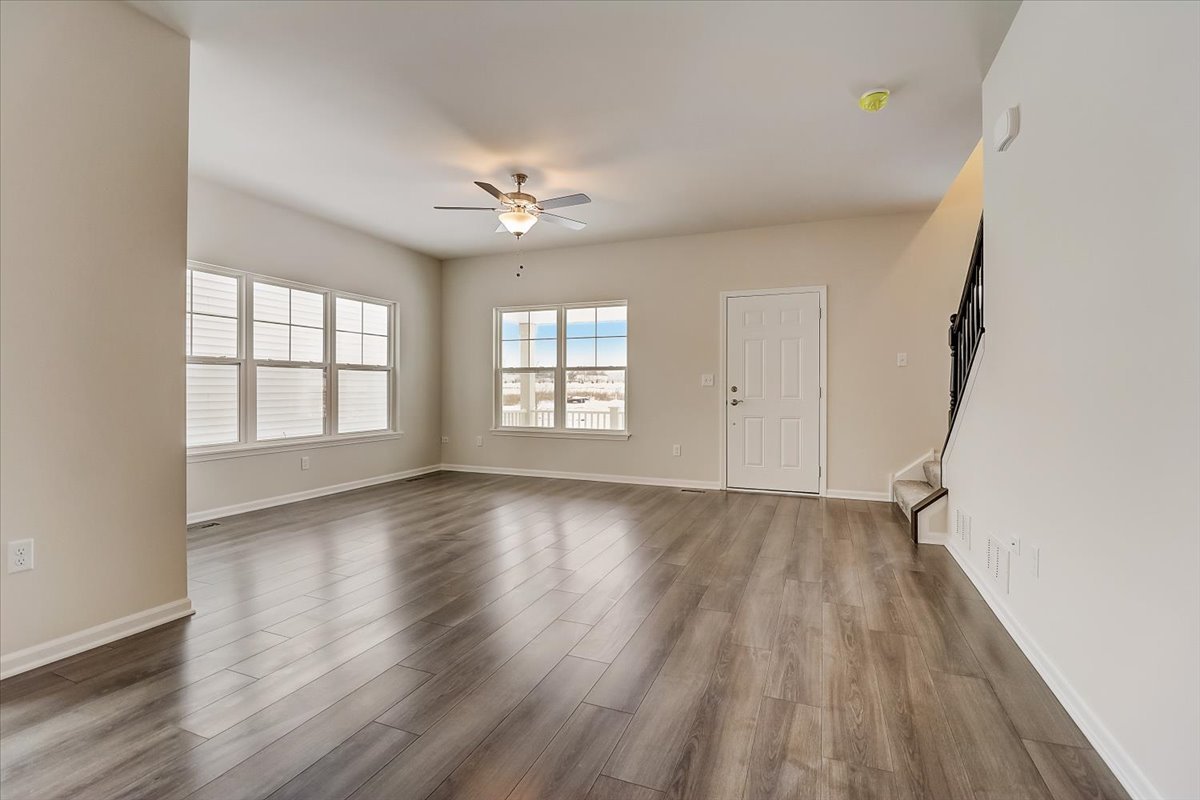715 Station Boulevard Elburn, IL 60119 - Photo 6 of 33 an empty room with wooden floor and windows