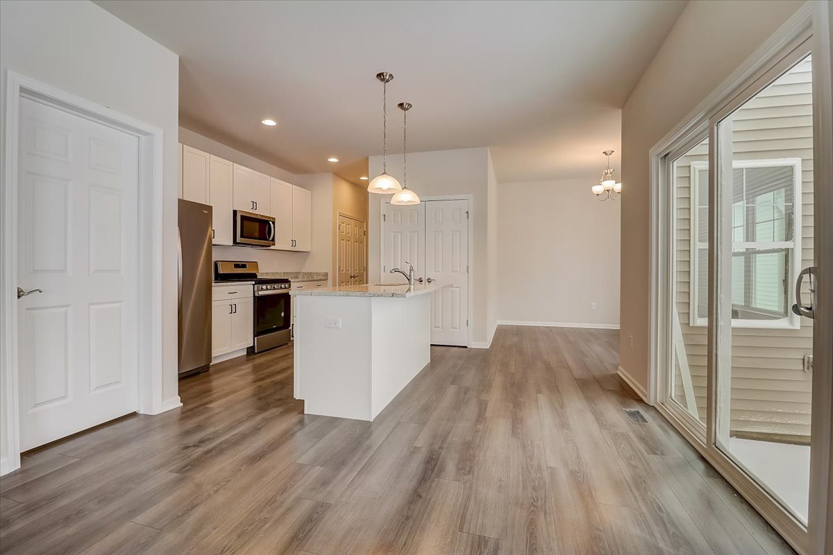715 Station Boulevard Elburn, IL 60119 - Photo 7 of 33 a view of open kitchen with wooden floor and electronic appliances