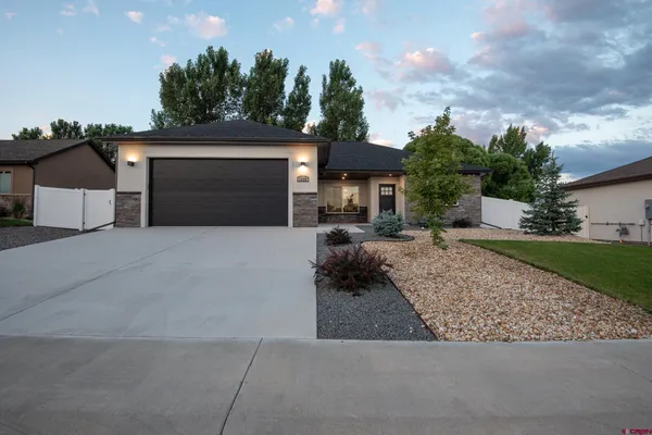 a front view of a house with a yard and garage