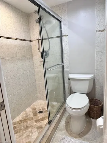 a white toilet sitting next to a shower