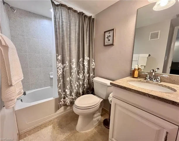 a bathroom with a granite countertop toilet sink and a mirror