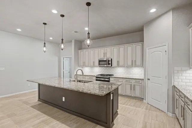 a large kitchen with kitchen island a sink stainless steel appliances and cabinets