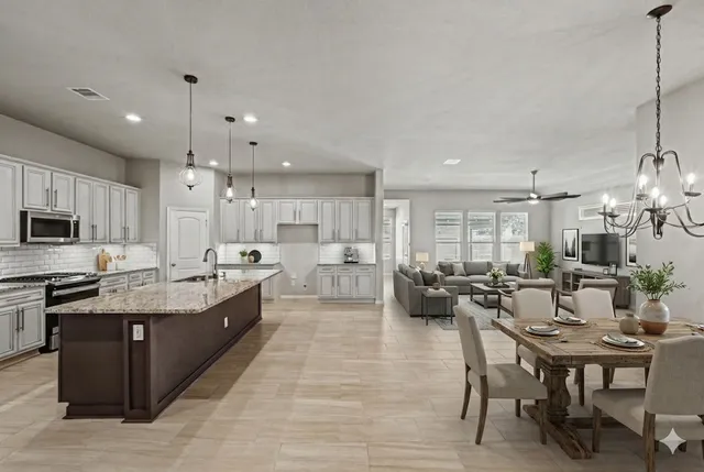 a large kitchen with kitchen island a sink table and chairs