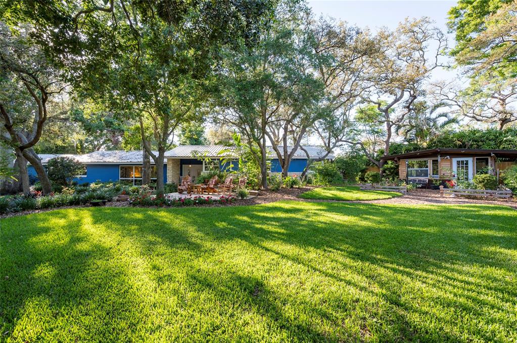 a front view of a house with garden and trees