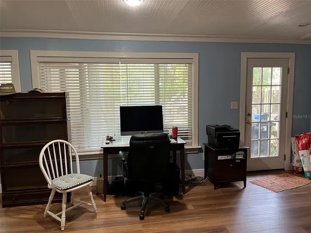 a dining room with furniture a chandelier and wooden floor