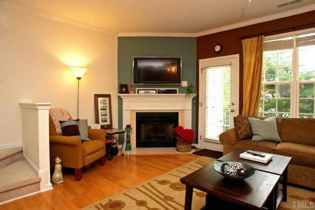 8322 City Loft Court Raleigh, NC 27613 - Photo 2 of 12 a living room with furniture a flat screen tv and a fireplace