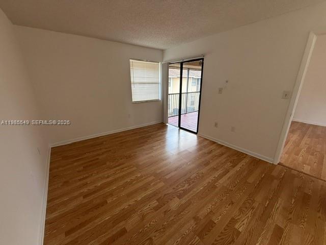 2255 Southwest 80th Terrace, Unit 2255 Miramar, FL 33025 - Photo 9 of 14 a view of an empty room with wooden floor and a window