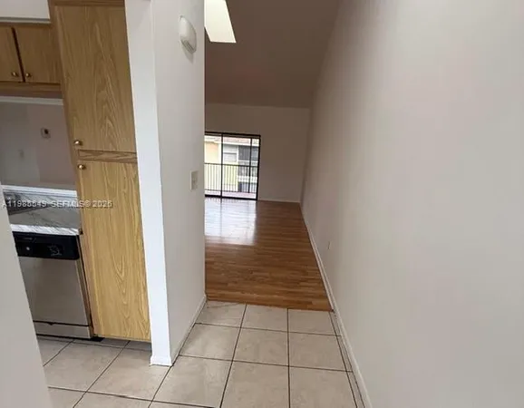 a view of a kitchen with fridge and wooden floor