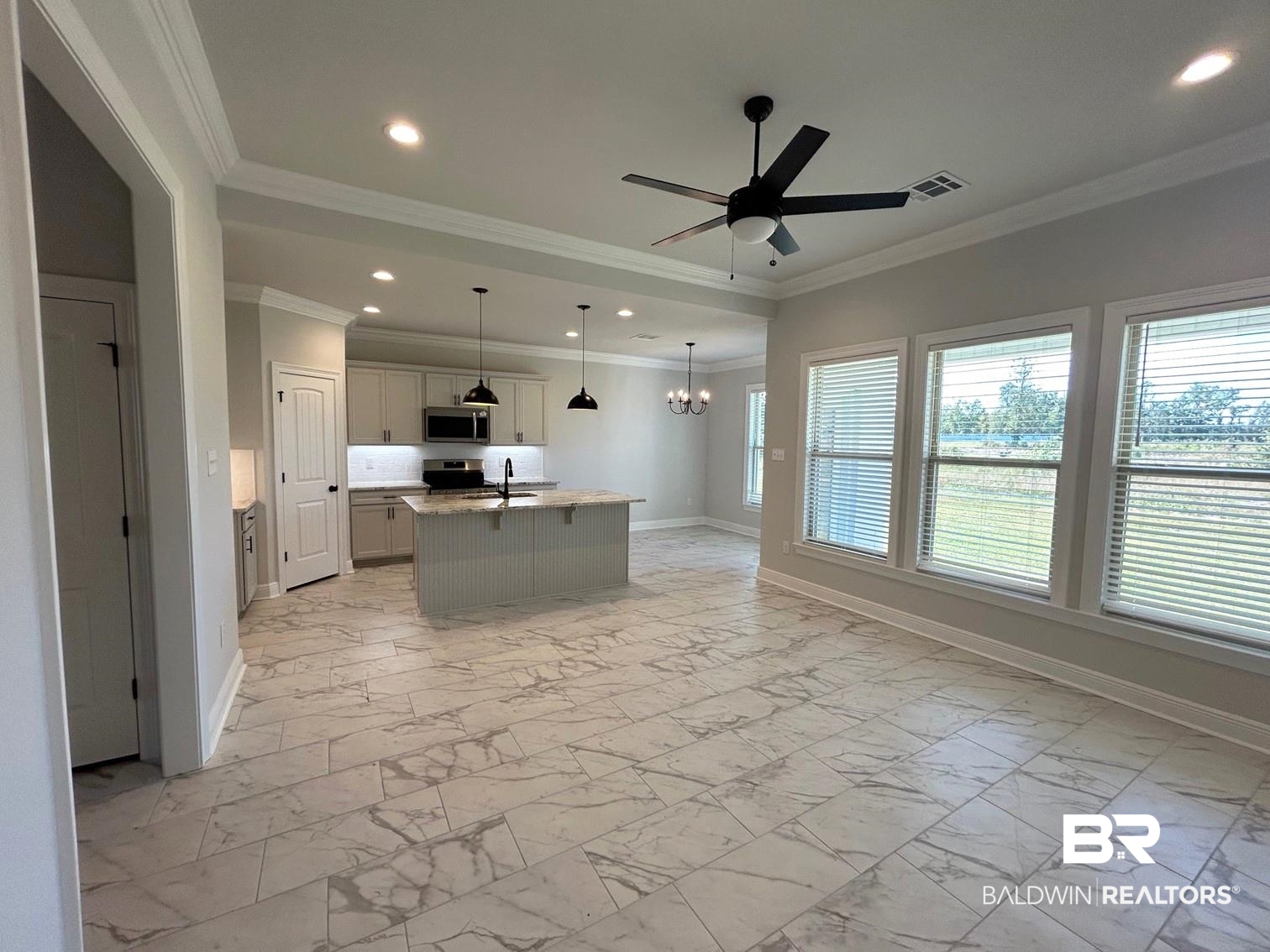 880 Sumter Loop Foley, AL 36535 - Photo 3 of 14 Kitchen with crown molding, ceiling fan with notable chandelier, pendant lighting, light stone counters, and a kitchen island with sink